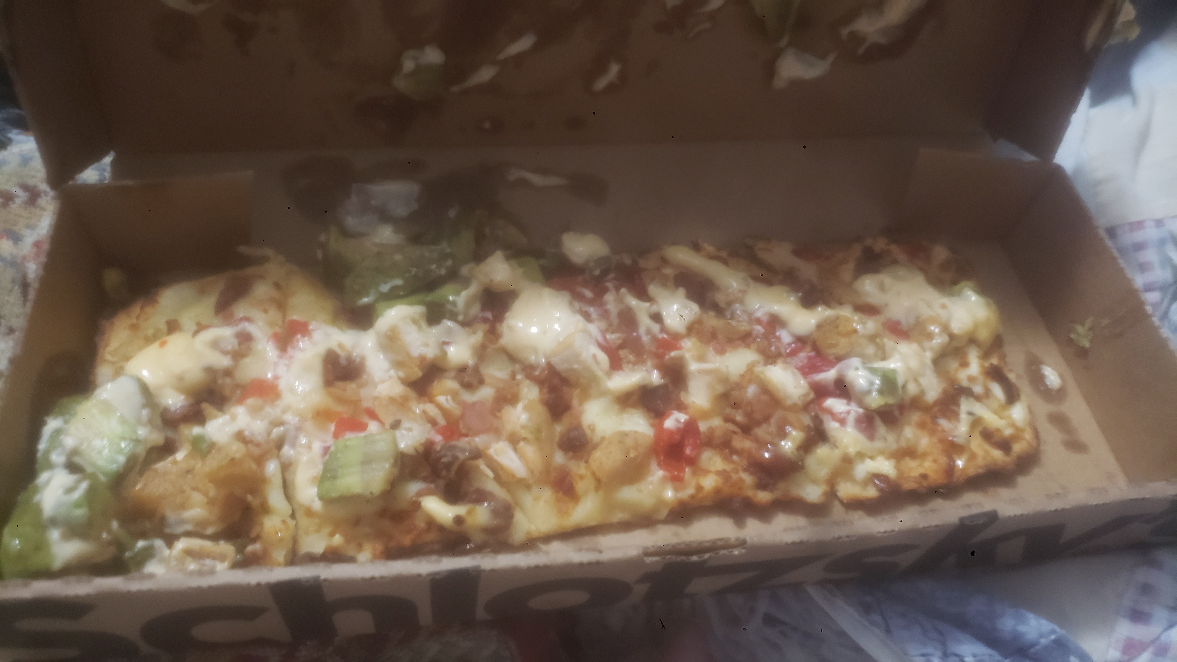 Chicken and avocado flatbread in a to go box.